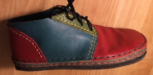 A multicolored chukka boot with a dark blue strip covering the visible frill sole.