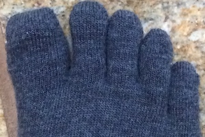 Photo of spread toes clad in grey wool toe socks.