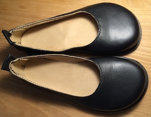 A pair of black leather court shoes with wide toes, seen from above so the pale leather lining is visible