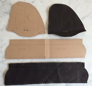 Two pieces of card, one D-shaped, the other like a long rectangle, and two identically shaped pieces of dark brown leather