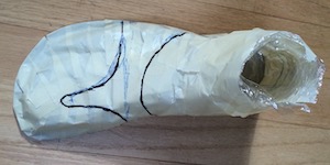 A masking tape cast of a foot, with black pen lines drawn on.