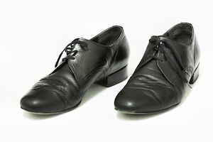 A pair of well-worn black men's dress shoes